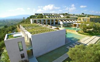 The modern cube structure of the single and two-storey residential buildings stand among olive trees that are more than 100 years old. © egreen / ZinCo Hotel complex with green roofs
